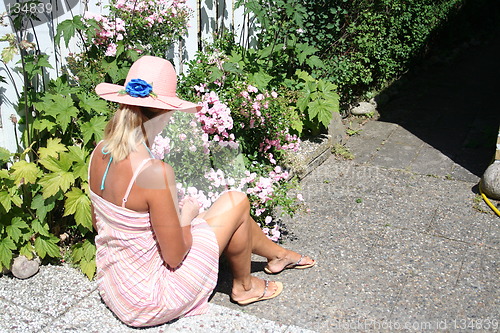 Image of Girl in pink colour sitting in the garden