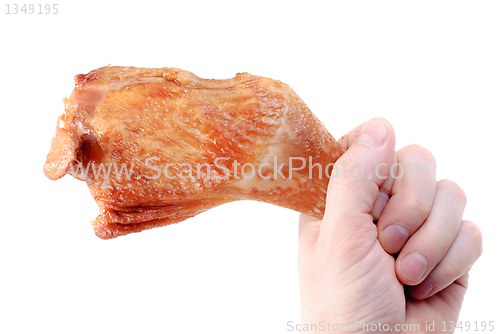 Image of Hand holds a hicken leg. Isolated on white  background