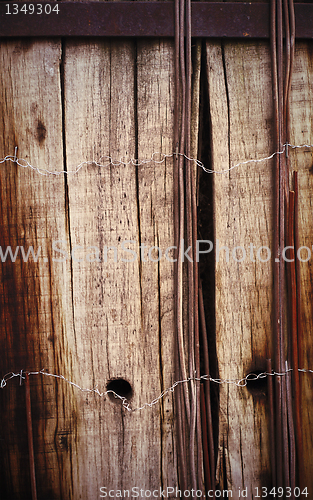 Image of Old board fence with rusty nails and a barbed wire