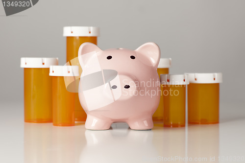 Image of Piggy Bank In Front of Several Medicine Bottles