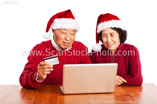 Image of Senior Asian couple shopping online celebrating Christmas