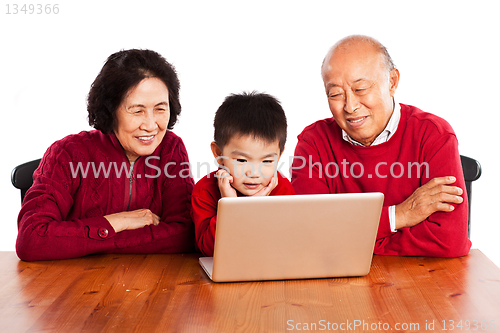 Image of Senior Asian grandparents using computer with their grandson