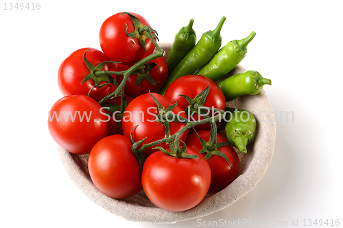 Image of Red tomatoes and green peperoni in basket