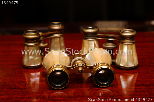 Image of Three binoculars on a brown desk