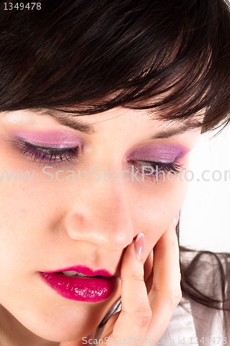 Image of Young woman holding her face