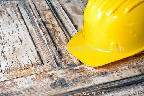 Image of Yellow helmet on burnt wooden log