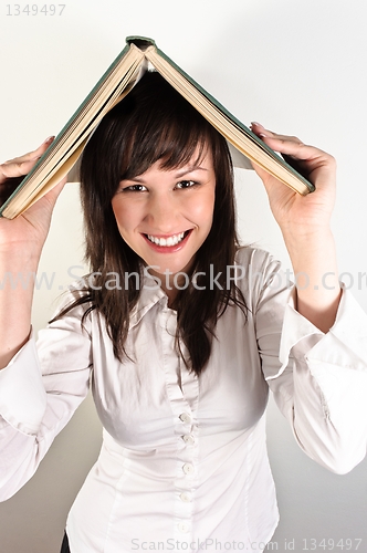 Image of Student girl holding book on her head