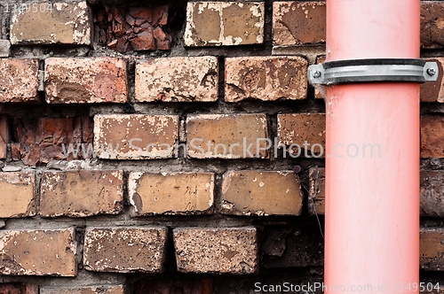 Image of Drain pipe against brick wall