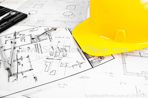 Image of Angle shot of some construction plans and a yellow helmet