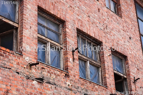 Image of An abandoned factory wall with broken windows