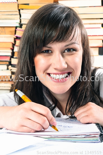 Image of Happy student girl writing in notebook