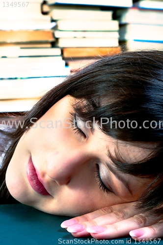 Image of Student girl sleeping on her books