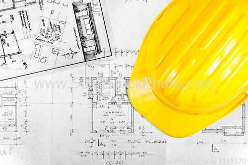 Image of Yellow helmet of an engineer with plans