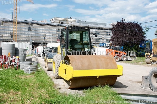 Image of Orange road-roller at construction site