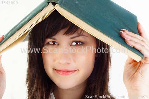 Image of Young university student with a book on her her against white is