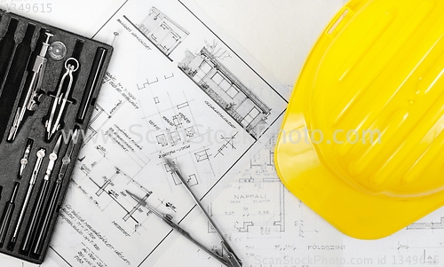 Image of Construction plans with yellow helmet on it