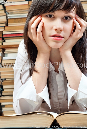 Image of Young student reading a book in the library