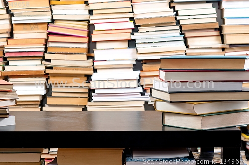 Image of Books piled up against black desk