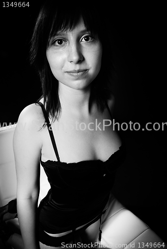 Image of Young woman in lingerie against dark balck background