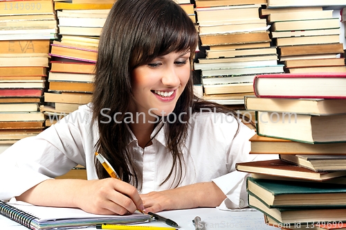 Image of Attractive student girl writing her homework