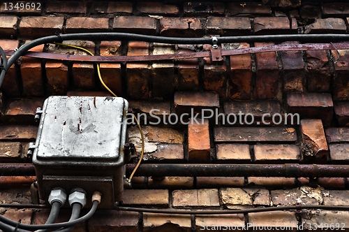 Image of Electric box on abandoned brick wall