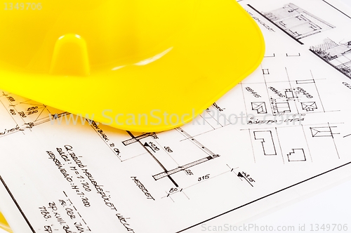 Image of Construction plans with yellow helmet on it