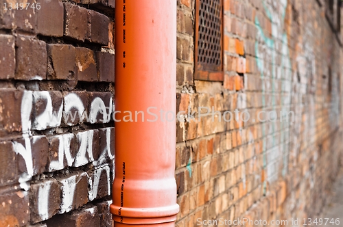 Image of Sewage pipe on brick abandoned wall