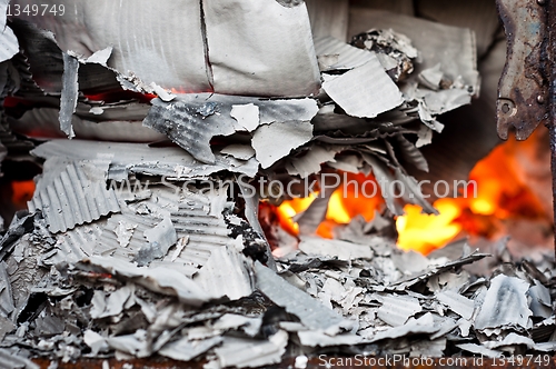 Image of Paper burning in recycle barrel