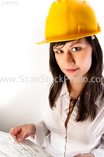 Image of Pretty business woman in yellow helmet holding her plans