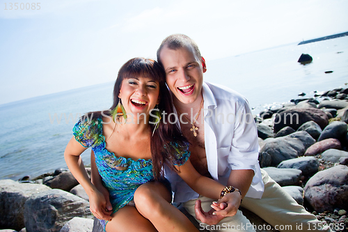 Image of laughing couple near of blue sea