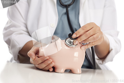 Image of Doctor Holding Stethoscope to Piggy Bank