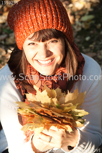 Image of woman with autumn orange leaves