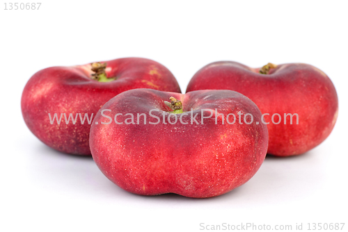 Image of Three red flat peaches 