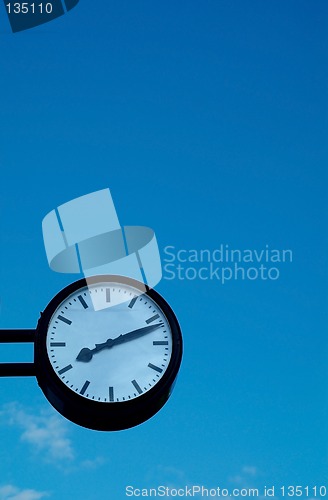 Image of Clock on blue sky background