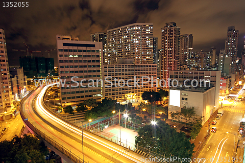 Image of blurred bus light trails in downtown night-scape 