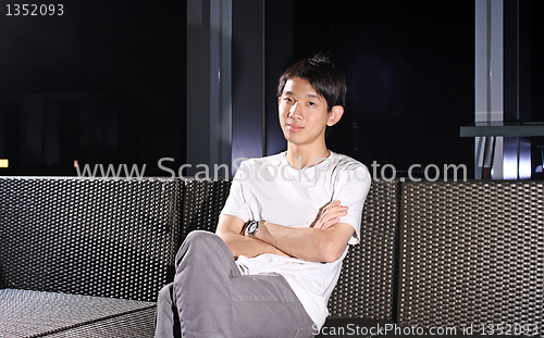 Image of Man sit on a bench while relaxing at a pub. 