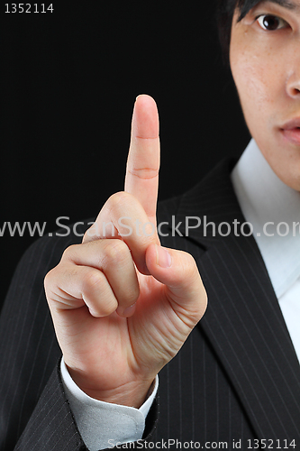 Image of young business man in a suit pointing with his finger