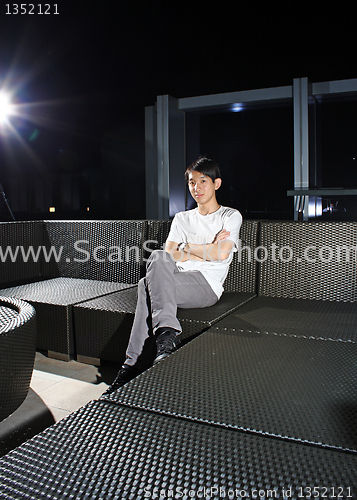 Image of Man sit on a bench while relaxing at a pub. 