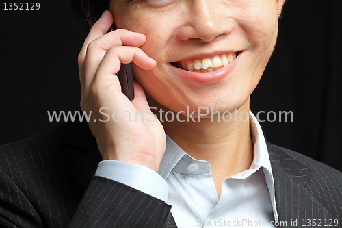 Image of portrait of e young man talking on mobile against a black backgr