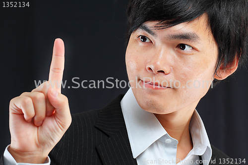 Image of young business man in a suit pointing with his finger