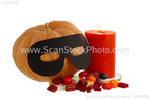Image of Halloween candies with candle and masqueraded pumpkin isolated