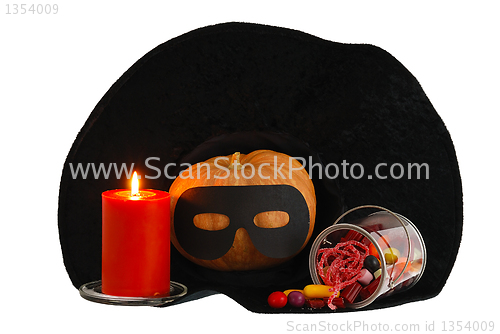 Image of Halloween candies with candle and  pumpkin in witch hat isolated