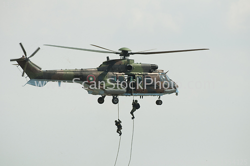 Image of Two soldiers hanging from a helicopter