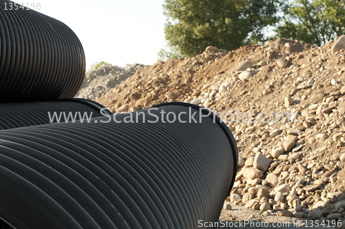 Image of Pipes and piles of sand in the background