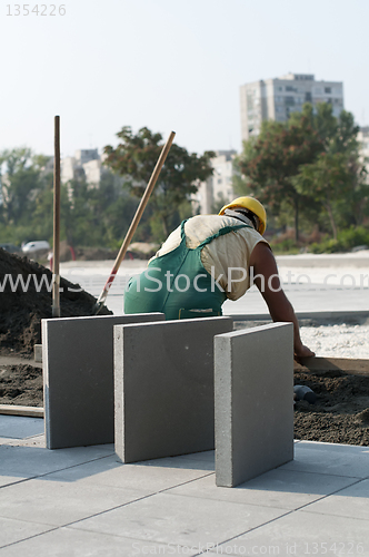 Image of A worker puts exterior tiles 