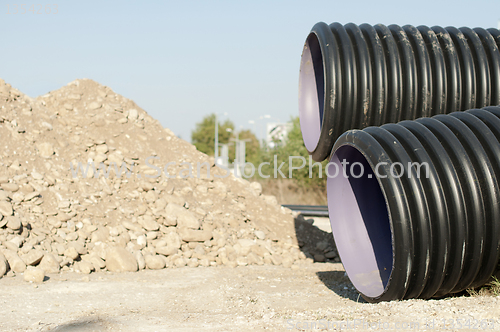 Image of Pipes and piles of sand in the background