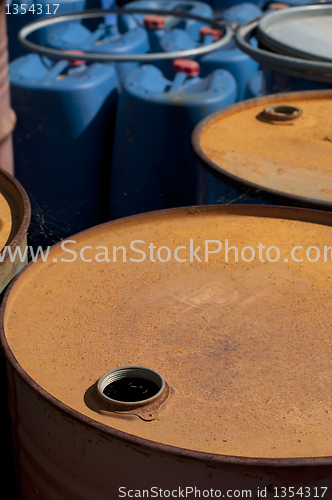 Image of Old colored oil barrels and blue canisters