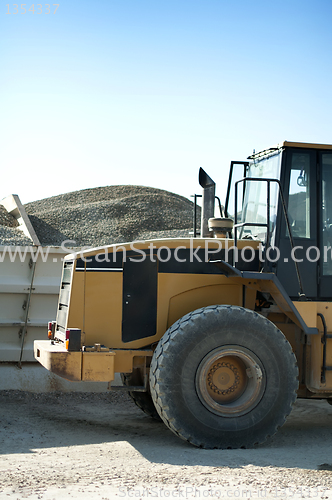 Image of Excavator close-up and piles of sand 
