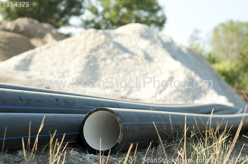 Image of Pipes and piles of sand in the background