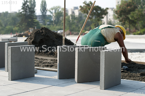 Image of A worker puts exterior tiles 